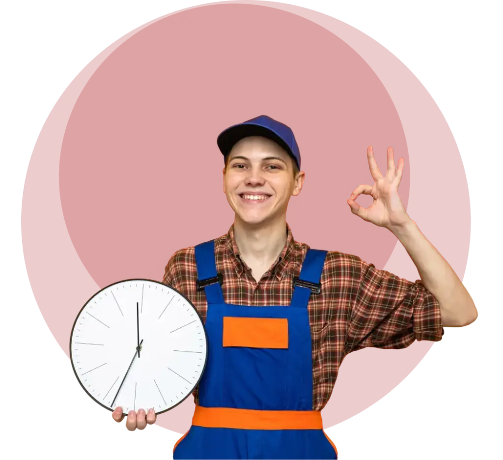 Glunderende klusjesman in blauwe overalls die een wandklok vasthoudt en een OK-gebaar maakt, wat een snelle en betrouwbare thuisreparatieservice vertegenwoordigt.