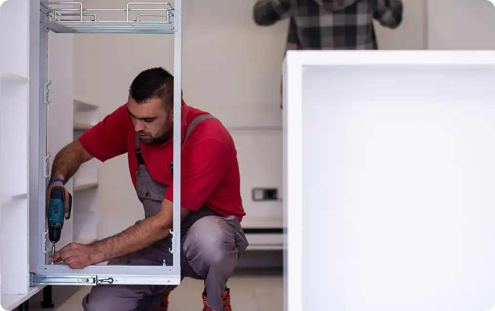 Technicus die een wasmachine repareert door interne componenten aan te passen tijdens een onderhoudsbezoek voor huishoudelijke apparaten.