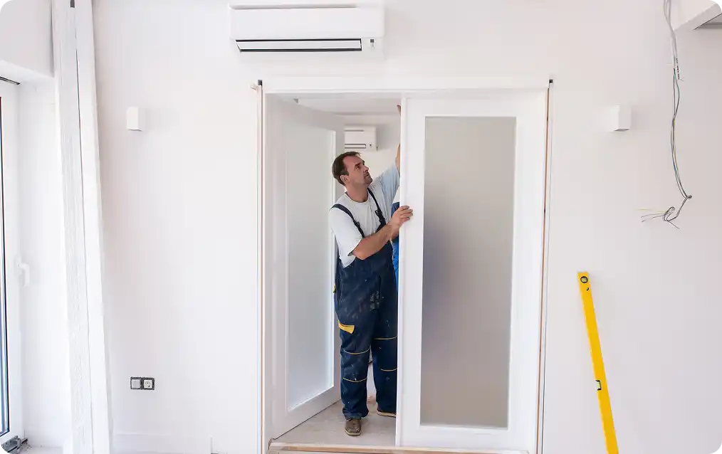 Klusjesman die een ingebouwd keukenapparaat in een kast installeert met behulp van elektrisch gereedschap.