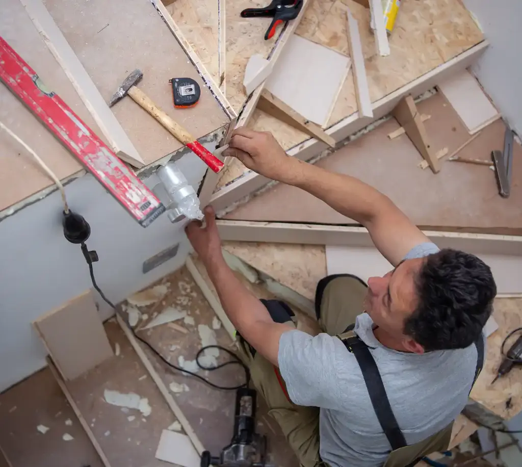 Technicus installeert vloerstructuurelementen en past materialen aan tijdens interieurrenovatie.